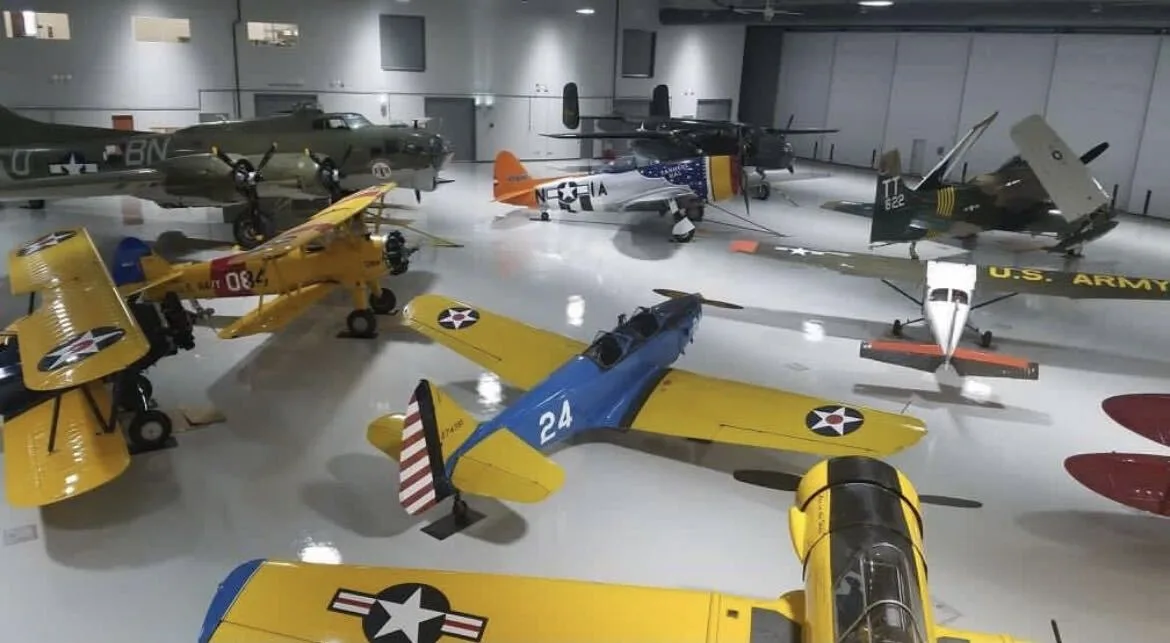 Aircraft hangar floor in a high-gloss white finish with vintage planes on display