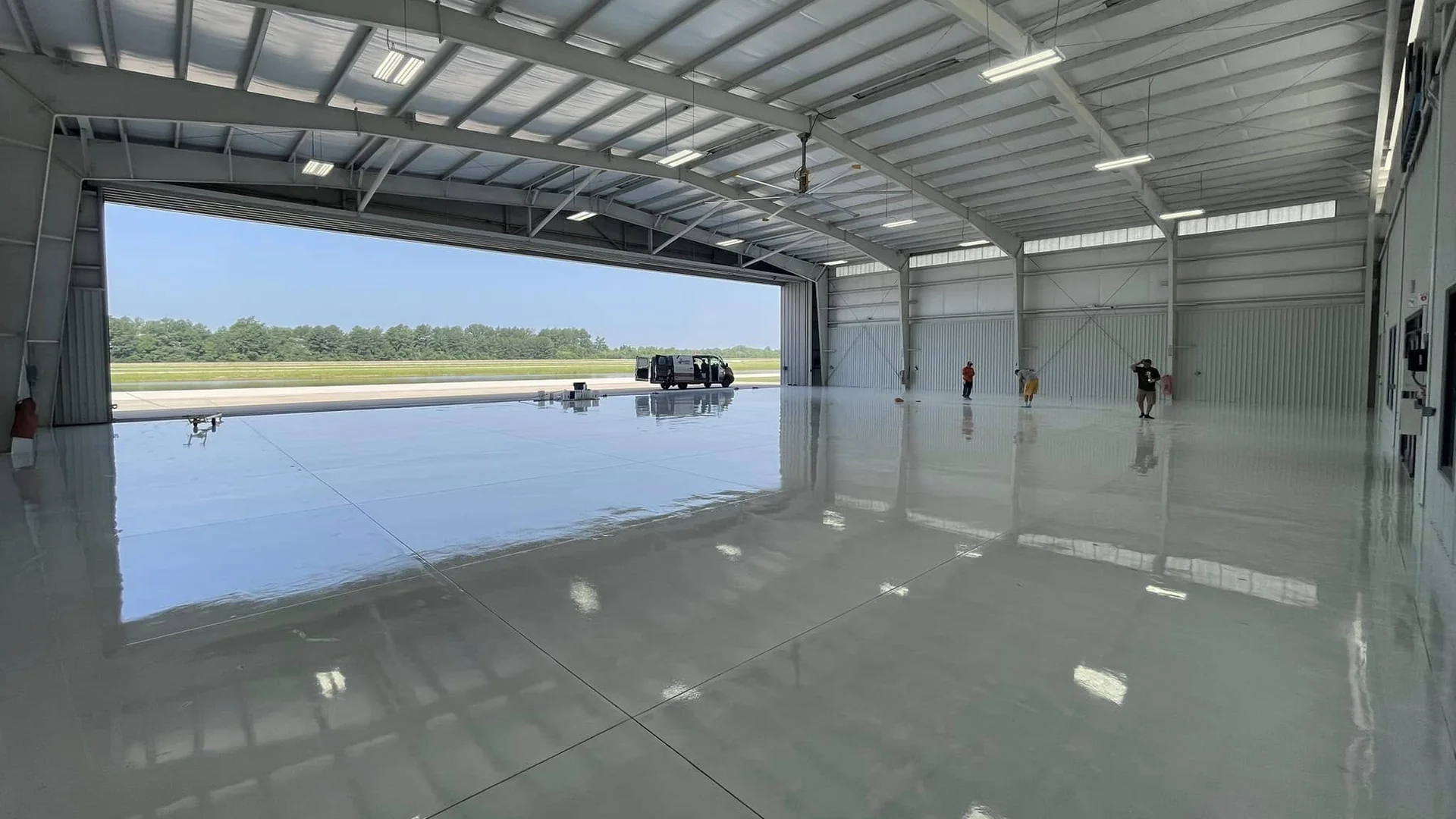 Aircraft hangar floor coated in high gloss with the hangar door open to the runway