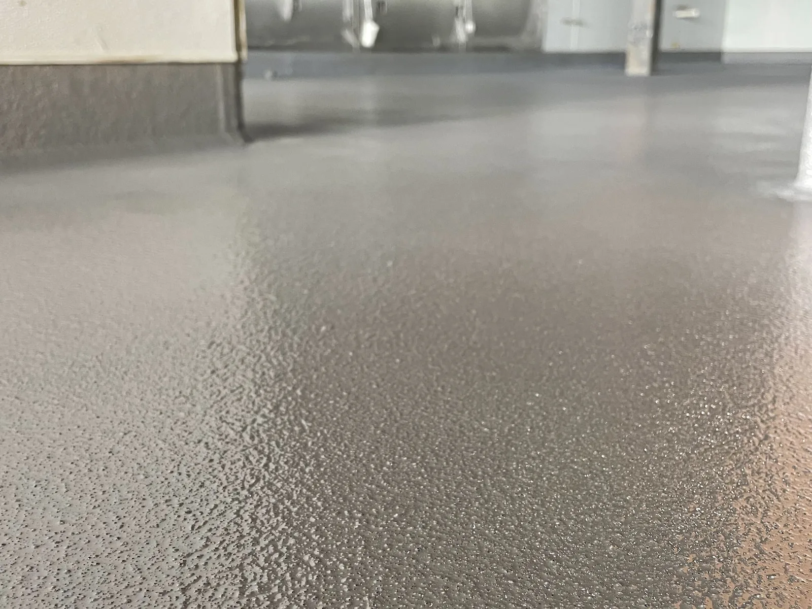 Close view of a textured anti-slip floor coating with grip aggregate