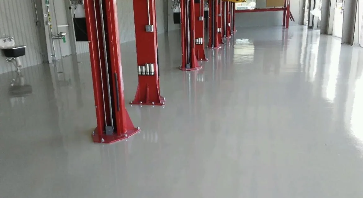Auto shop floor coating with two-post vehicle lifts