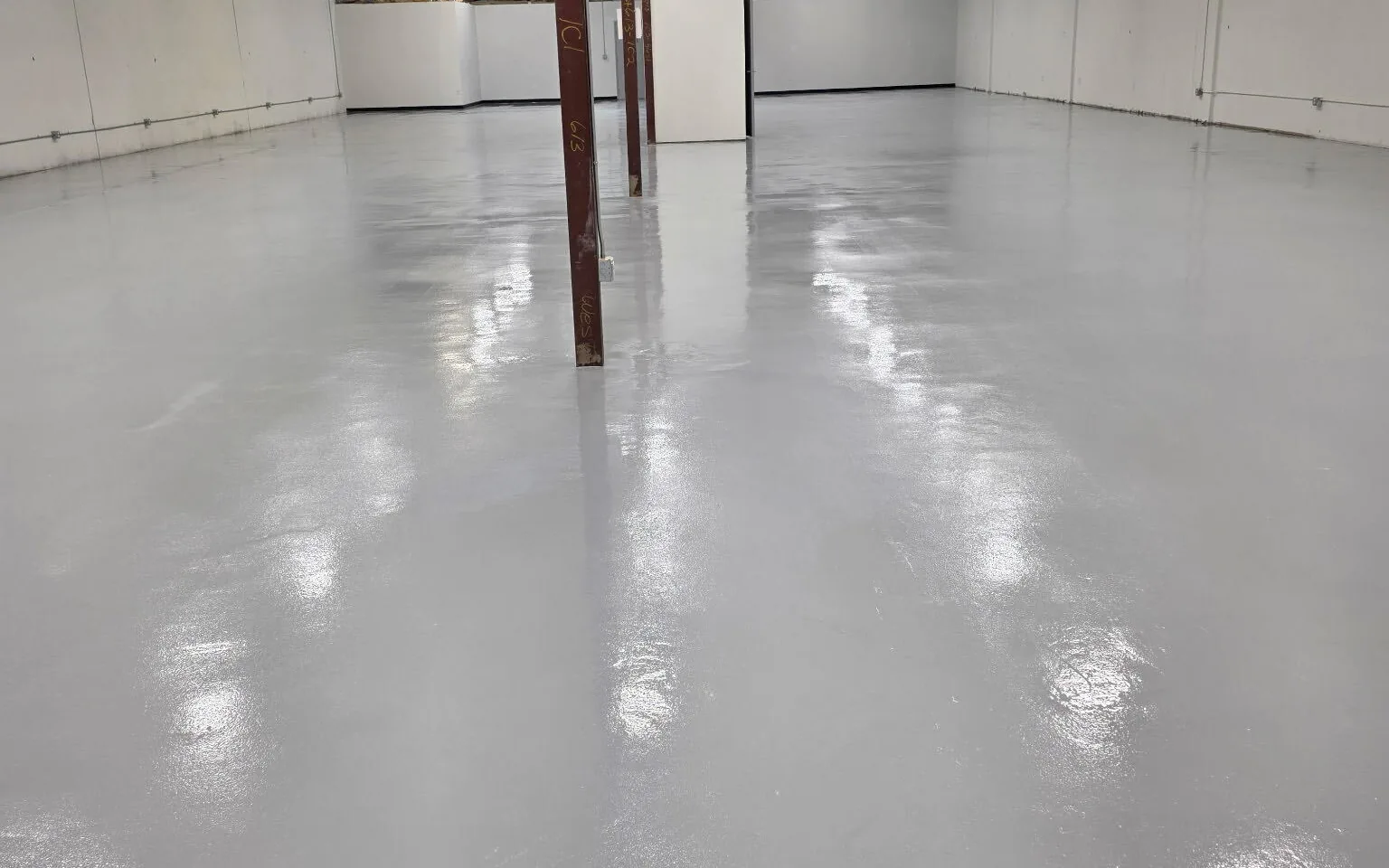 Light gray coated warehouse floor running the length of the building