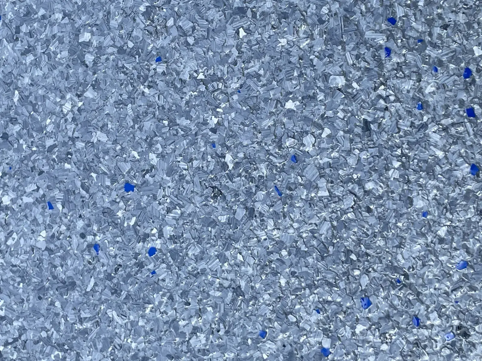 Close-up of a gray and blue flake epoxy floor with a clear high-gloss topcoat
