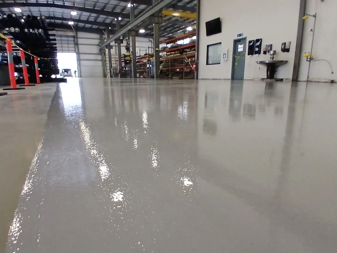 Glossy coated warehouse floor with pallet racking and safety bollards