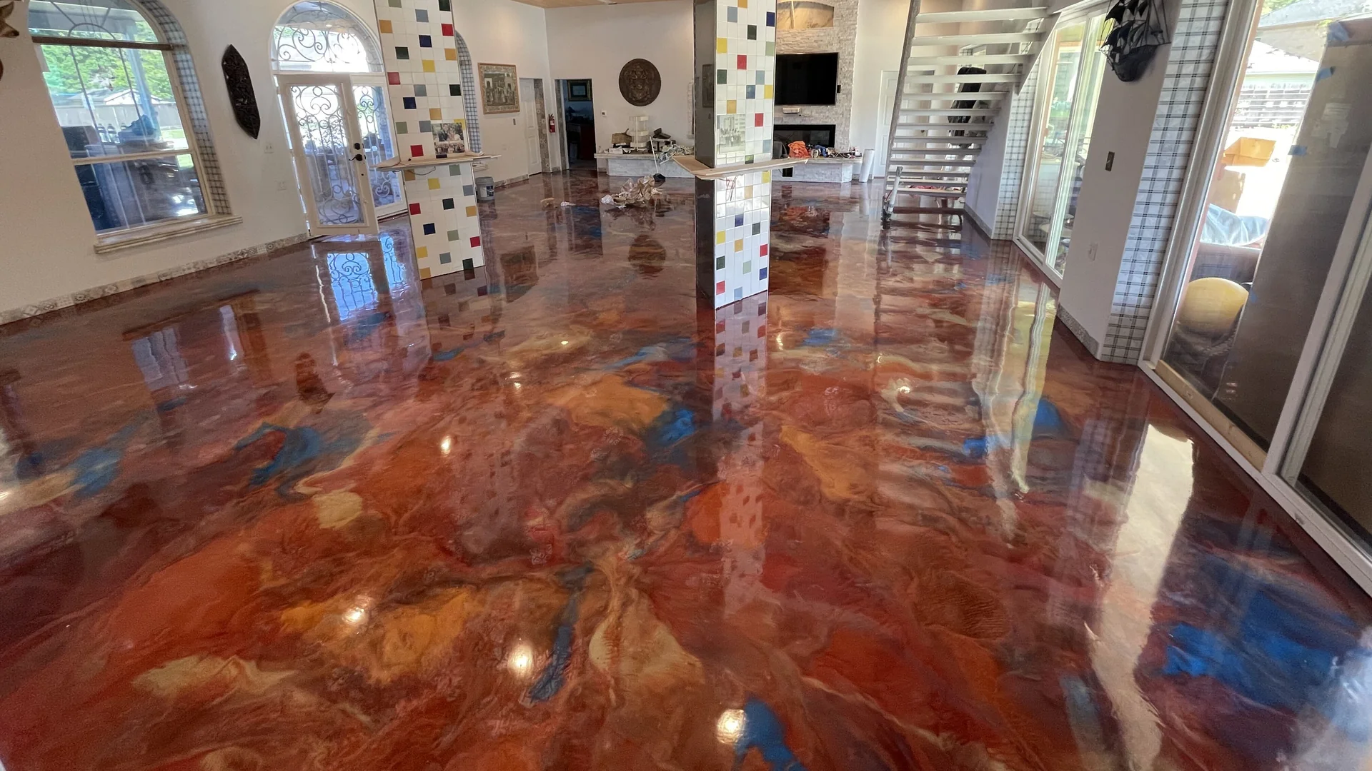 Copper and blue metallic epoxy floor across an open living area