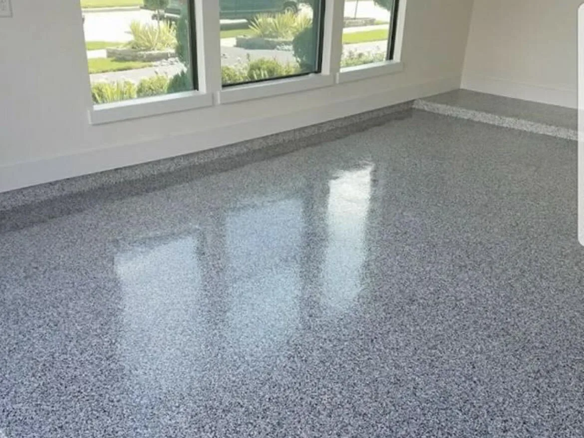 Gray flake epoxy floor in a bright room with a window wall