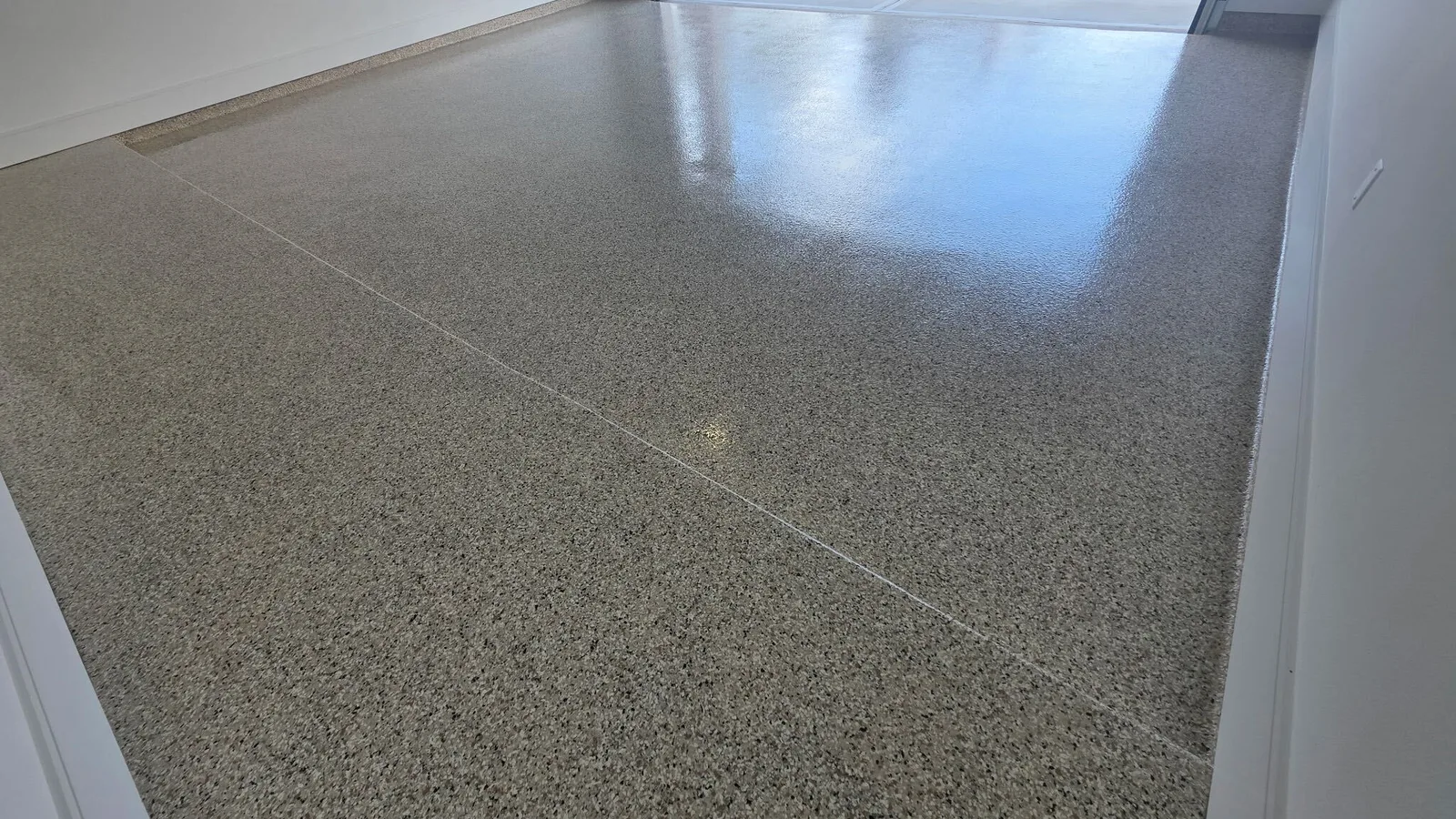Wide tan flake epoxy garage floor under a high-gloss topcoat