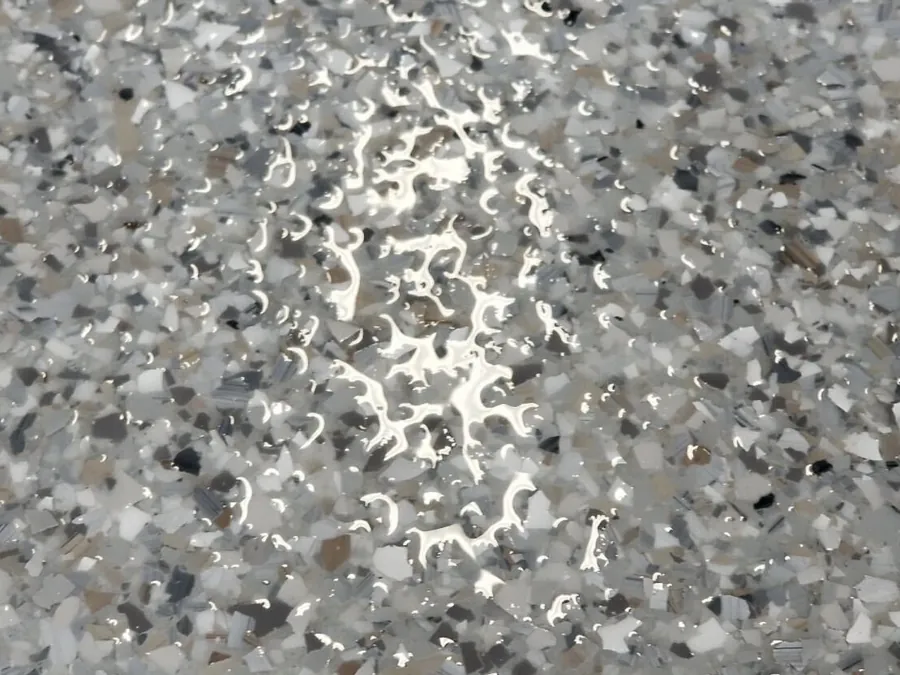 Tan, white and black flake chips under a clear coat, close up