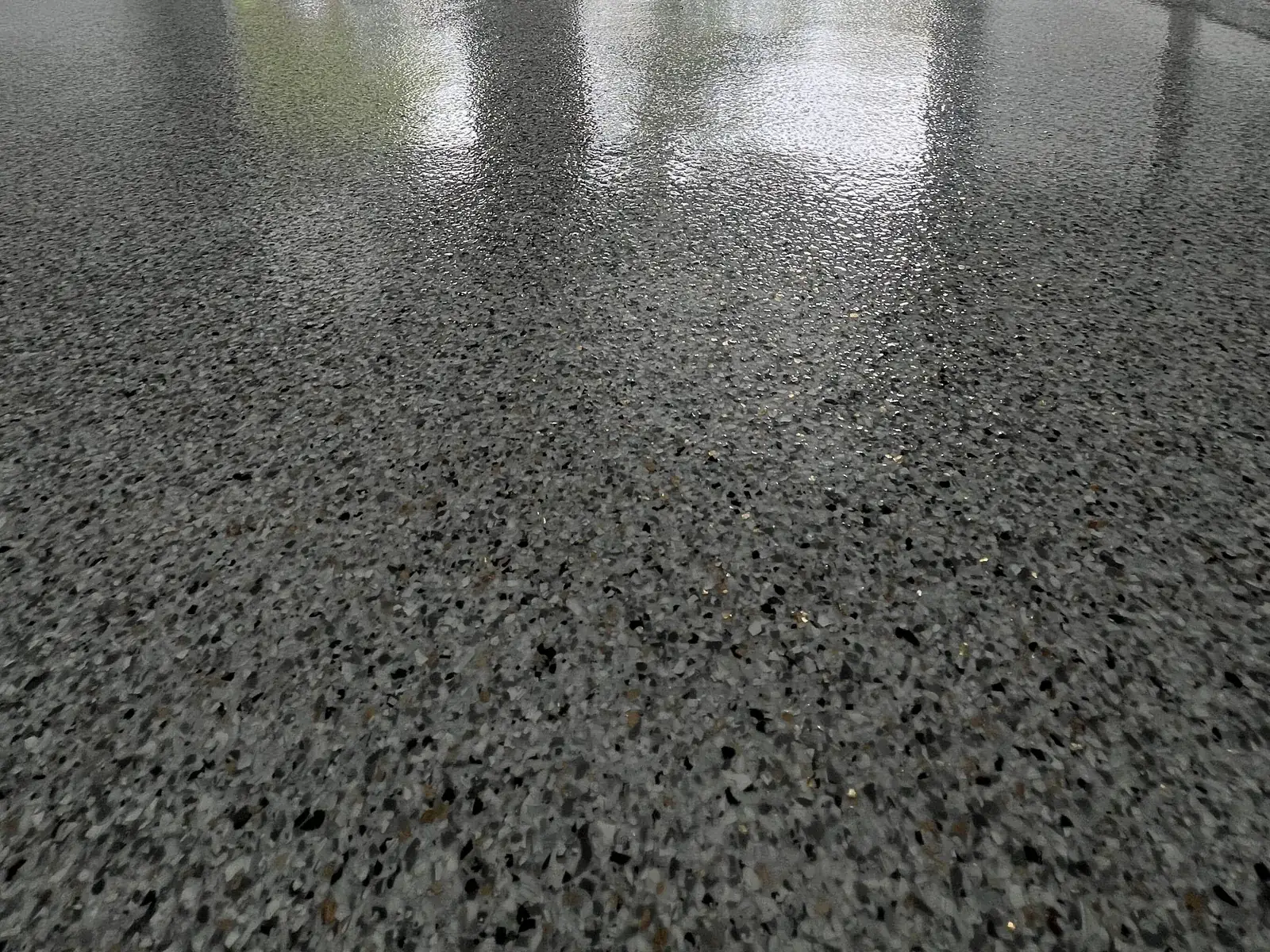 Gray flake epoxy garage floor under a clear topcoat with the door open