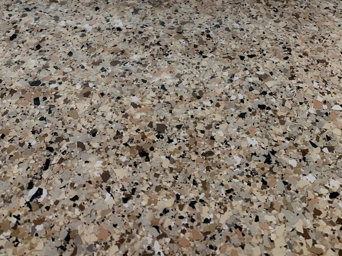 Close-up of a tan, brown and black full flake coating under a clear topcoat