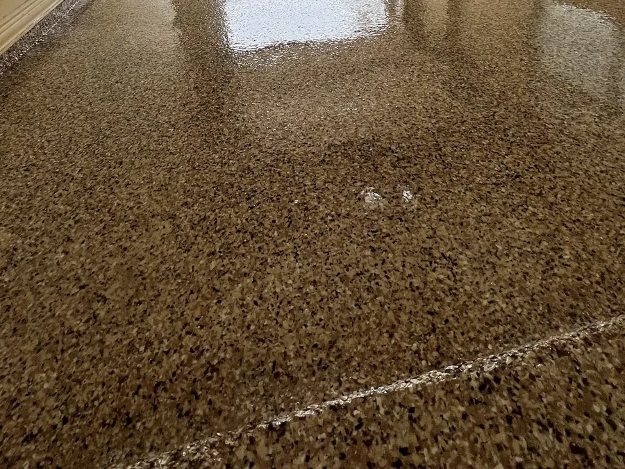 Tan flake garage floor with the clear topcoat still wet