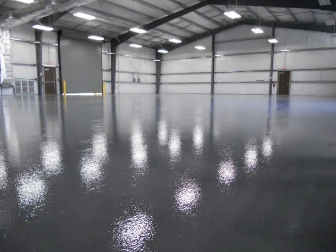 Gray solid color epoxy warehouse floor reflecting the overhead lights
