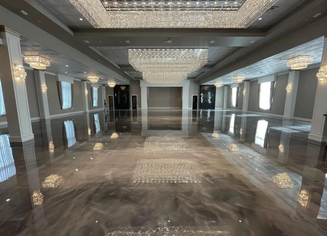 Metallic epoxy floor in a ballroom reflecting crystal chandeliers