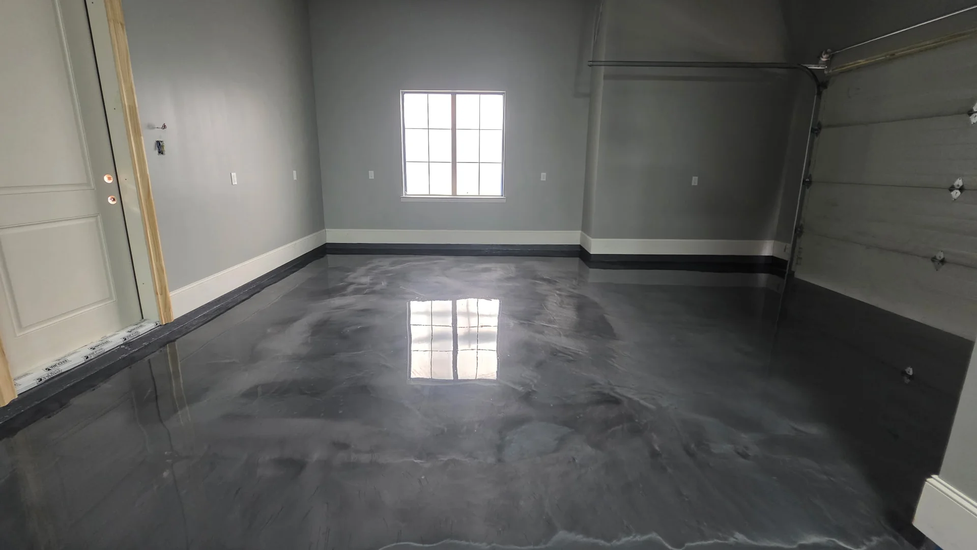 Charcoal metallic epoxy garage floor reflecting the window light