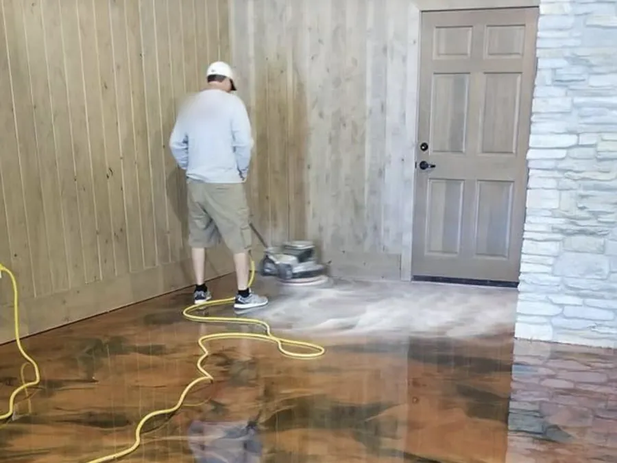 Copper metallic epoxy floor being buffed beside a wood plank wall