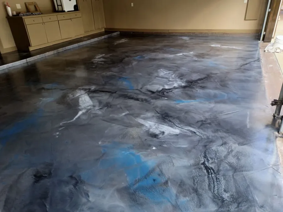 Gray, blue and black metallic epoxy floor in a garage with cabinets