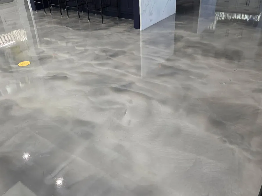 Gray metallic epoxy floor in a kitchen with a white island