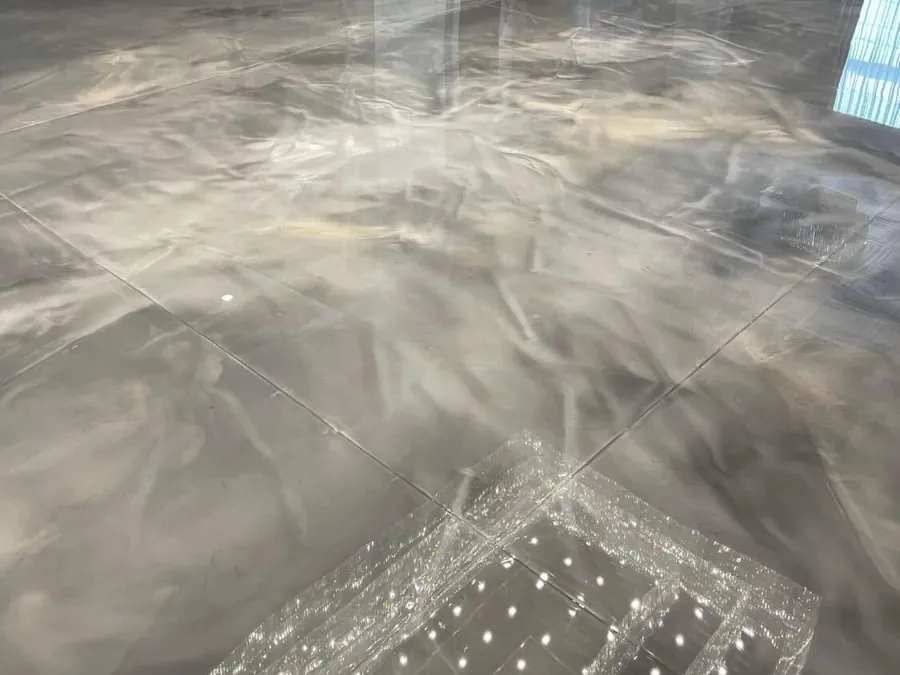 Silver metallic epoxy floor reflecting a chandelier