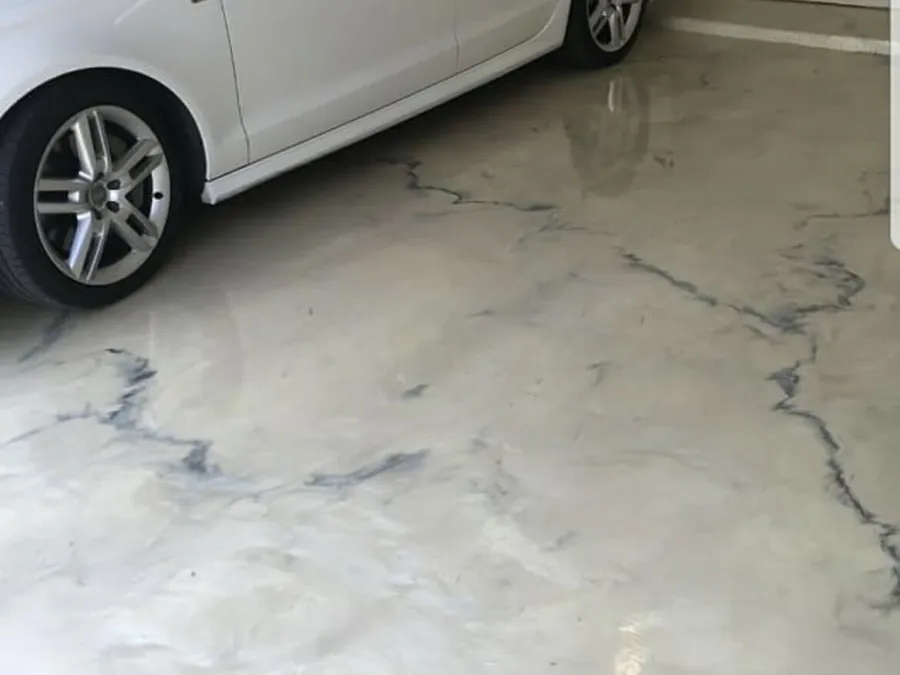 White marble look metallic epoxy garage floor with a car parked on it
