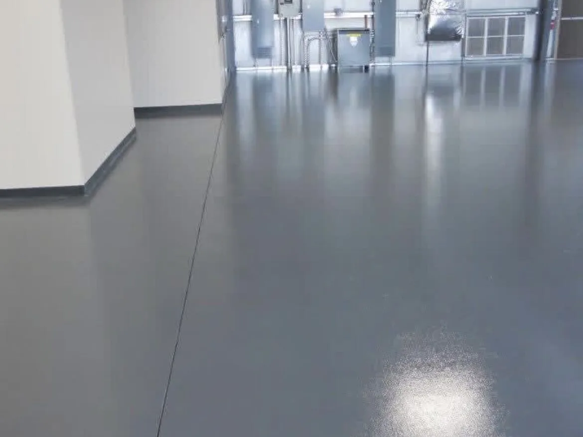 Gray coated shop floor with cove base running past mechanical equipment