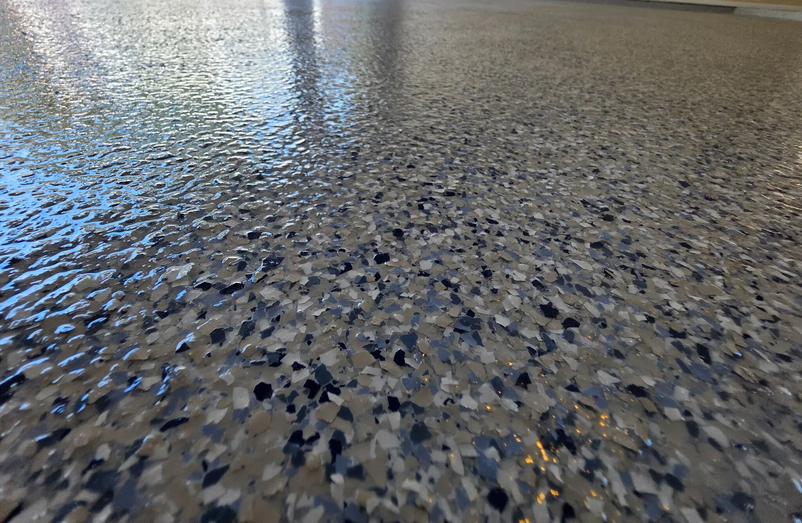 Close-up of a finished flake floor coating under a glossy clear topcoat