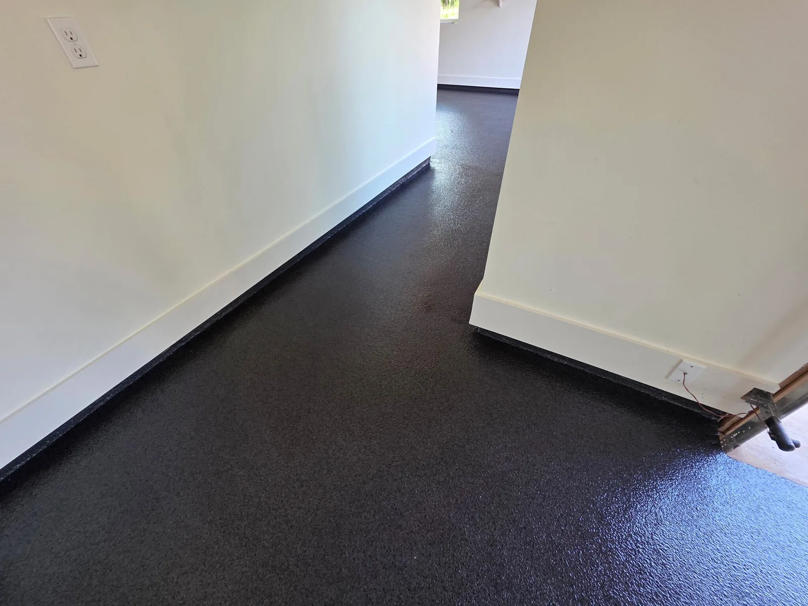 Dark charcoal floor coating with a satin gloss in an interior room