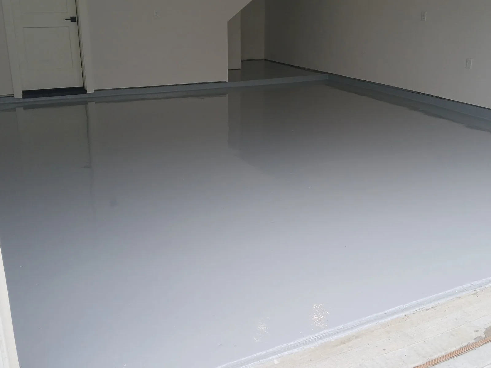 Smooth satin gray sealed concrete floor in an empty garage