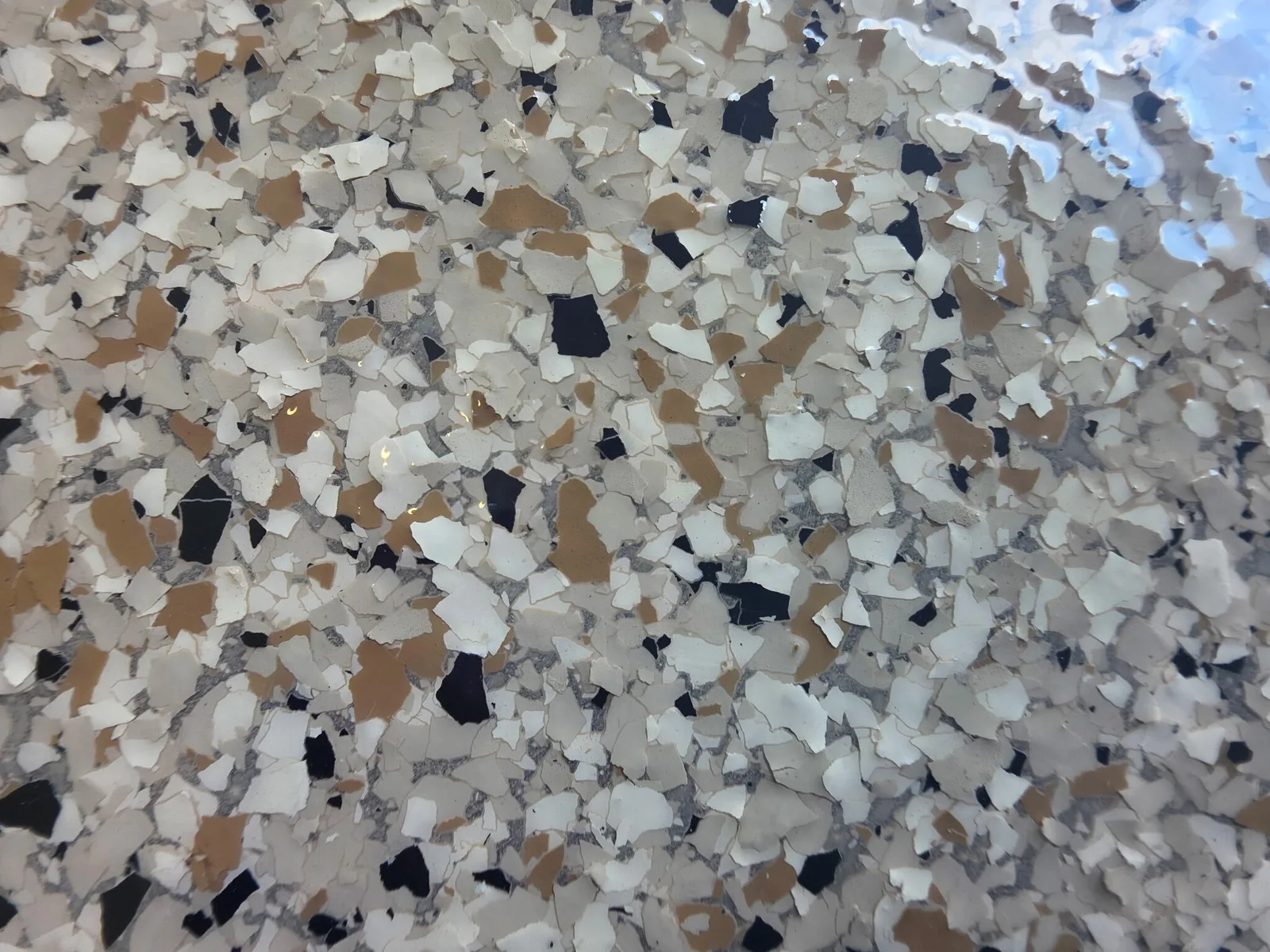 Close-up of tan, cream and black epoxy flake under a clear coat