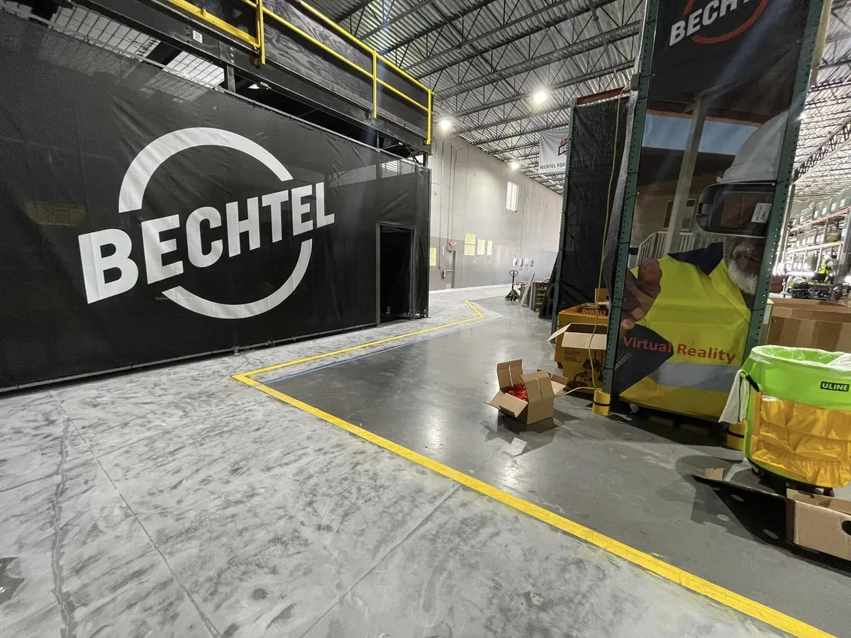 Coated safety walkway with a yellow border in front of a Bechtel banner