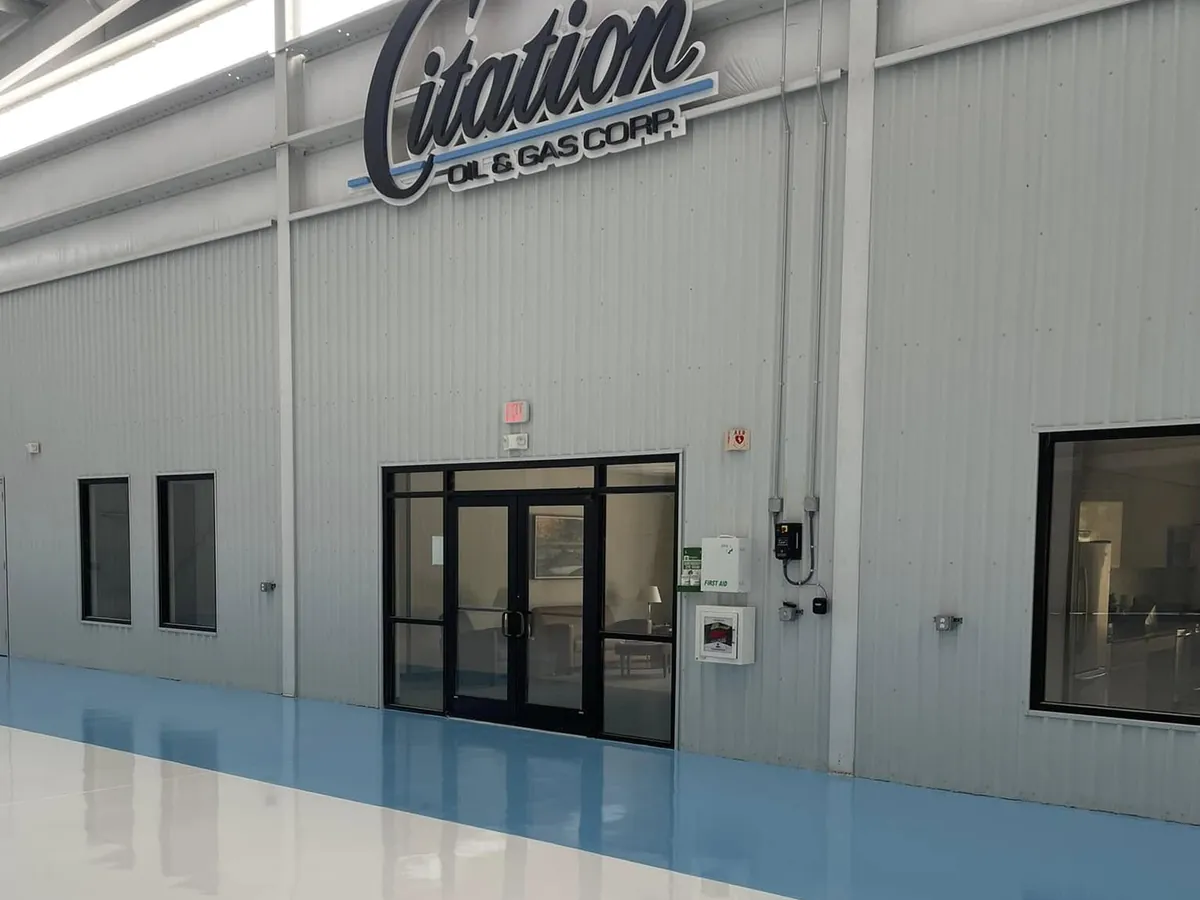 Blue and white two-tone hangar floor coating beneath the Citation Oil and Gas sign