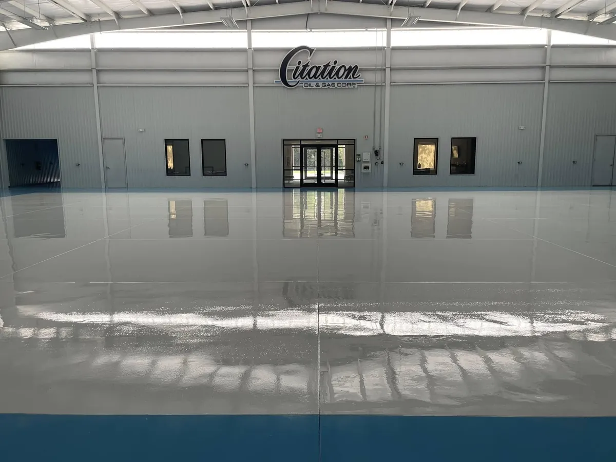 Finished white and blue hangar floor beneath the company sign