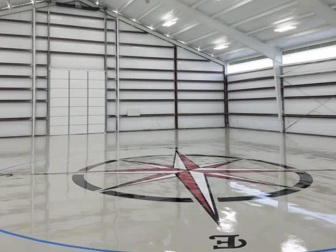 Compass rose logo set into a high-gloss gray hangar floor