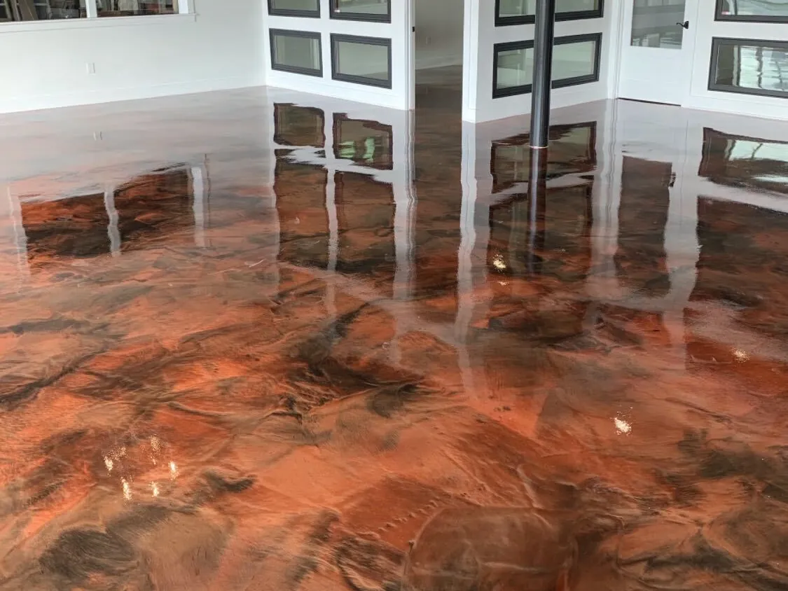 Copper metallic epoxy floor in a room with a chandelier and wood-frame windows