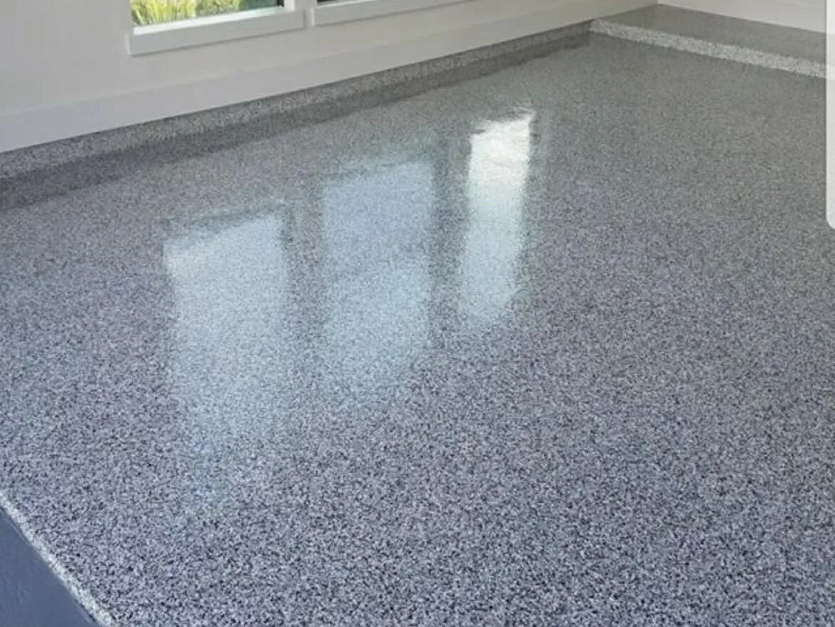 Gray flake epoxy floor in a bright room with a window wall