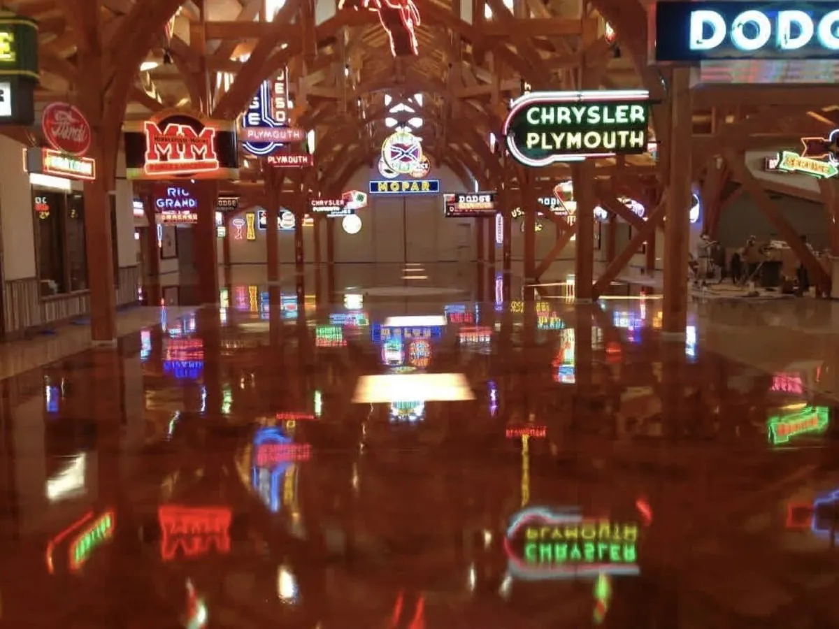 Red and gold metallic epoxy floor under the timber frame and neon at Hemi Hideout
