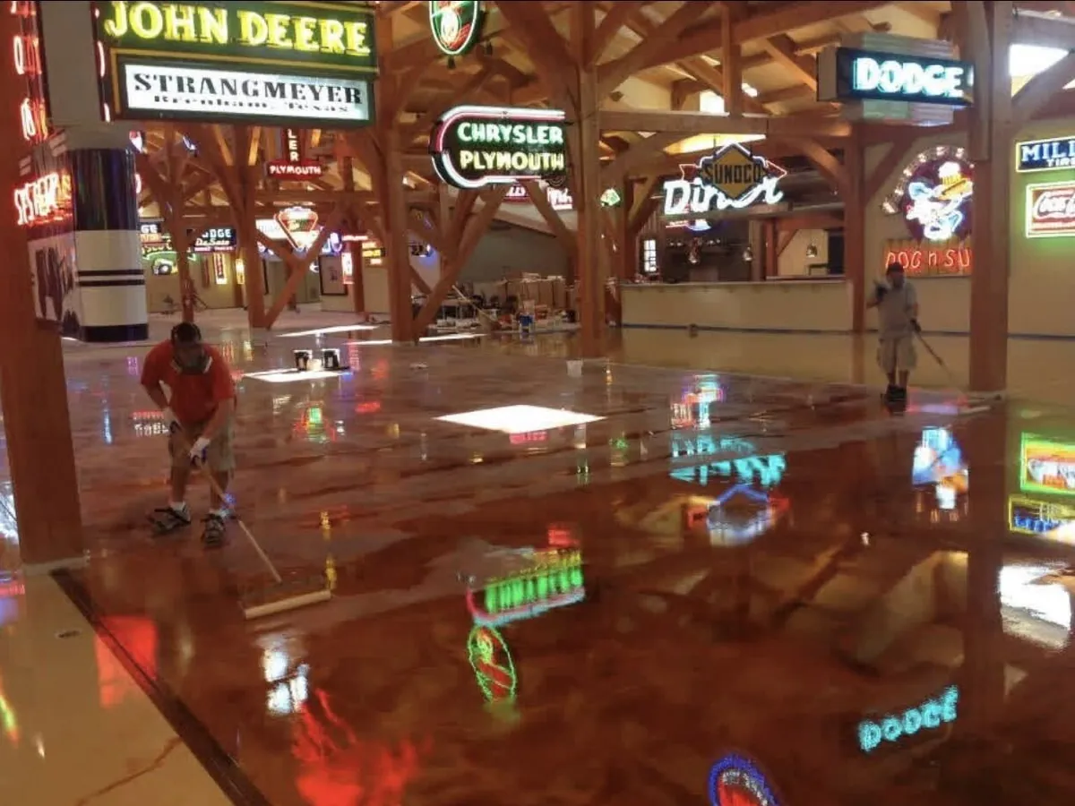 Crew hand working the metallic epoxy across the venue floor at Hemi Hideout