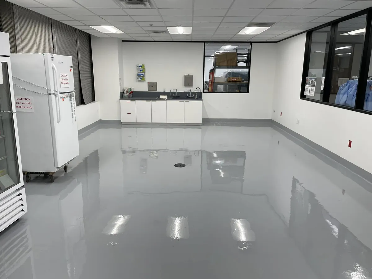 Gray high-gloss lab floor with a floor drain and lab casework