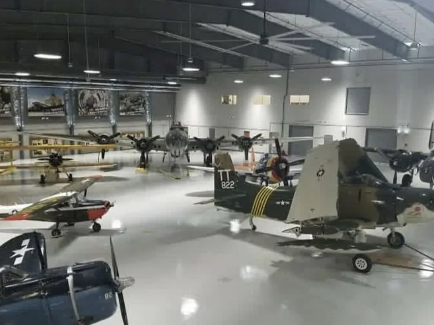Vintage aircraft on display across the coated hangar floor at the Lone Star Flight Museum
