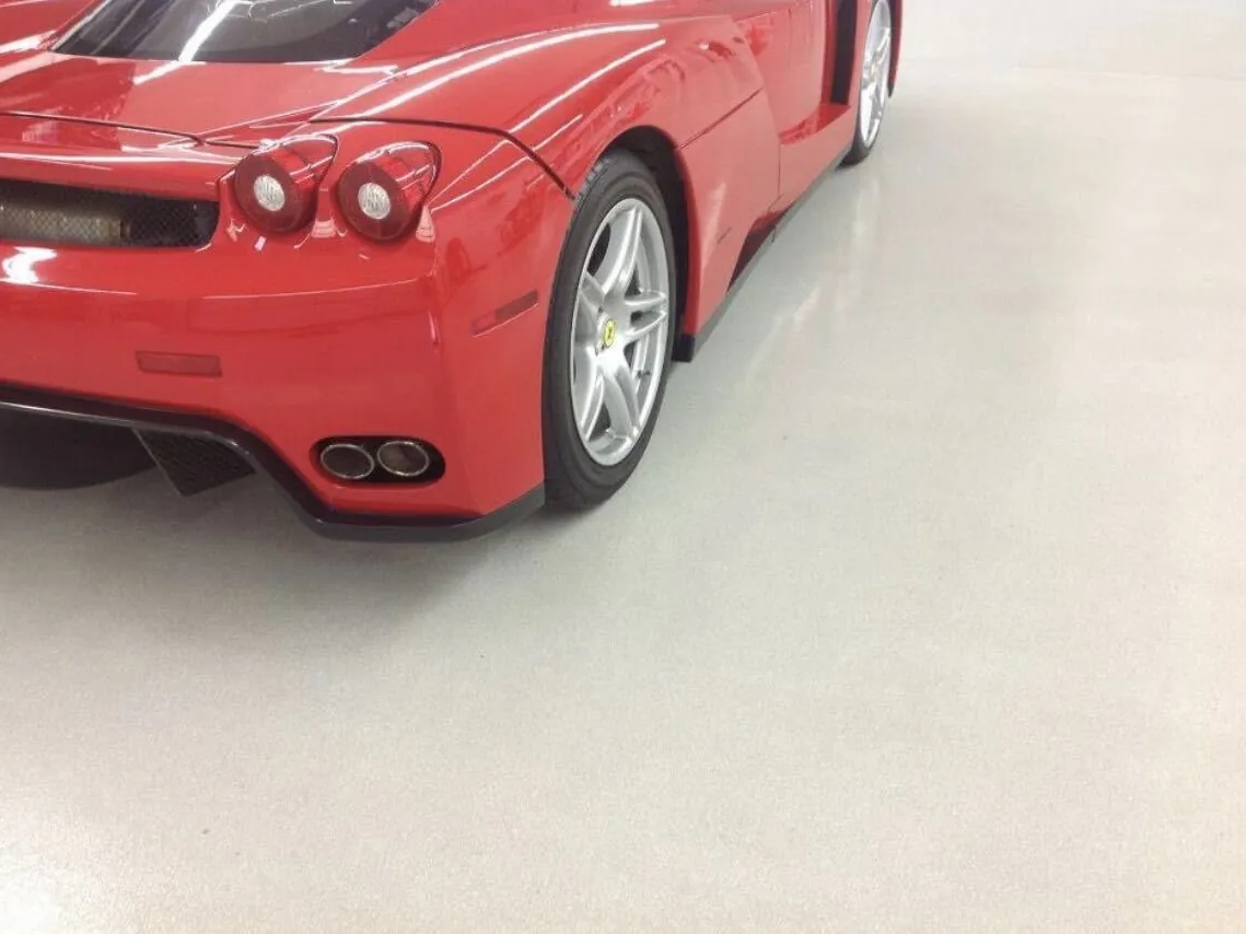 Red sports car on a white solid-color garage floor