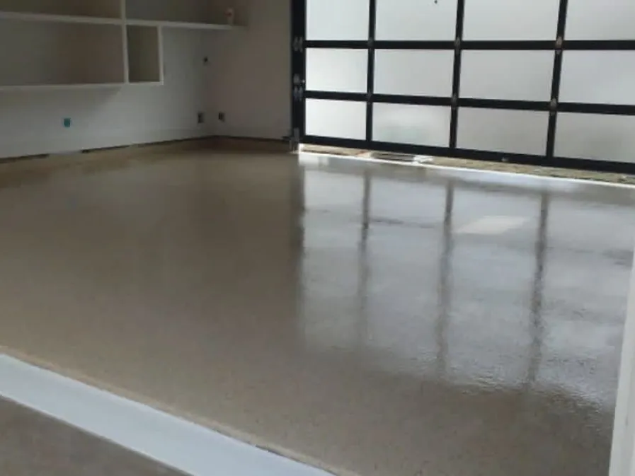 Tan high-gloss garage floor coating beside a glass garage door